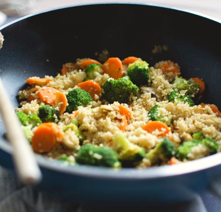 Couscous mit Brokkoli und Karotten in einer Pfanne